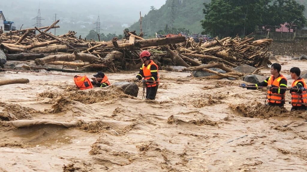 Rescue workers helping a flood survivor in Nepal